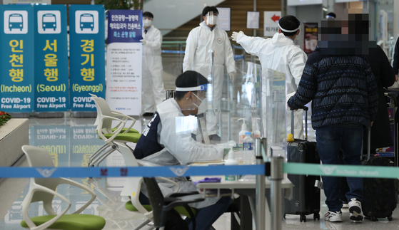 Visitors from Osaka, Japan, are guided towards buses headed to Covid-19 testing sites Wednesday at Incheon International Airport, as health authorities announced Korea detected two new cases of the new coronavirus variant spreading through Britain. [YONHAP]