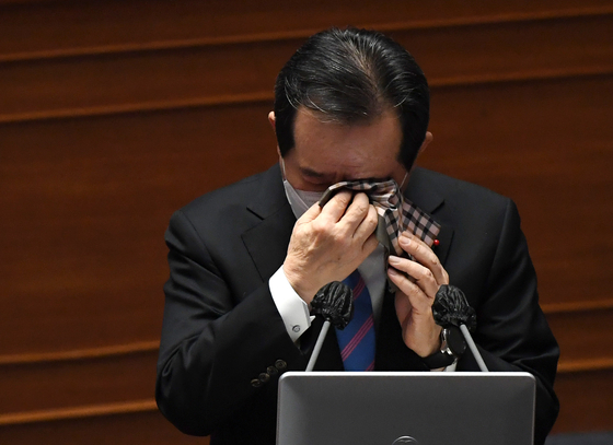 Prime Minister Chung wipes his tears after responding to a question about small business owners' crisis in the Covid-19 pandemic in Korea at a session at the National Assembly in Seoul on Friday. [YONHAP]