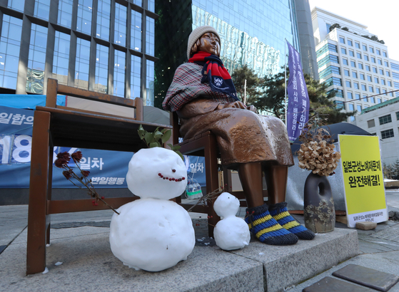 A statue representing comfort women victims near the former Japanese embassy in central Seoul is bundled up for the cold weather, as a local court made a landmark ruling Friday that the Japanese government is responsible for paying damages to victims of its wartime sexual slavery. [YONHAP]