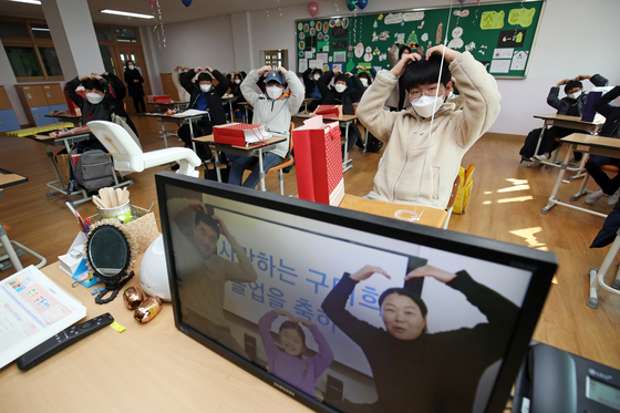 Sixth graders of the Jungheung Elementary School in Gwangju attend an 'untact' graduation ceremony on Tuesday while their parents participate by videoconference to observe the ceremony. [NEWS1]