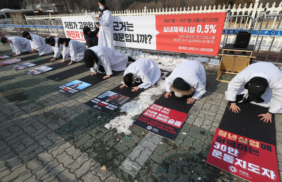 Representatives of a federation of Pilates and fitness center owners take a deep bow as they urge the government Tuesday in front of the National Assembly in Yeouido, western Seoul, to allow them to reopen their businesses. [YONHAP] 