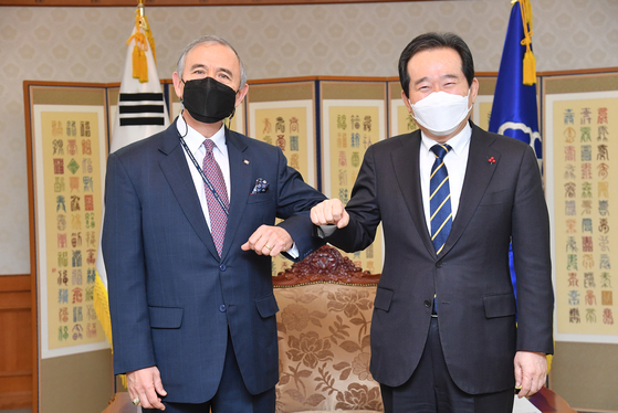 Prime Minister Chung Sye-kyun, right, bumps elbows with outgoing U.S. Ambassador to Korea Harry Harris Monday at the government complex in central Seoul. [PRIME MINISTER’S OFFICE]