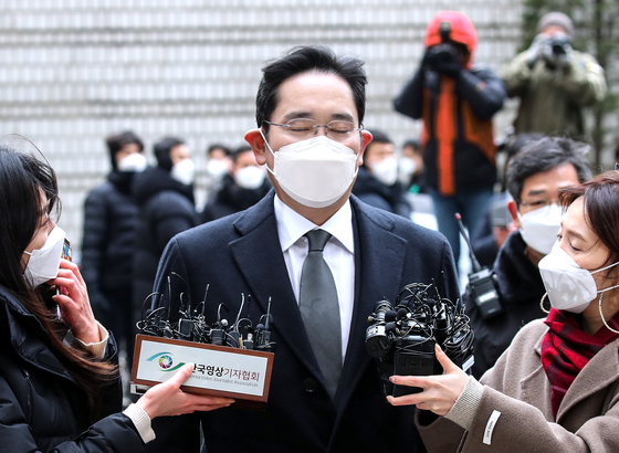 Samsung Electronics Vice Chairman Lee Jae-yong is questioned by reporters before appearing at a hearing Monday in his trial for giving bribes to former President Park Geun-hye. [WOO SANG-JO]