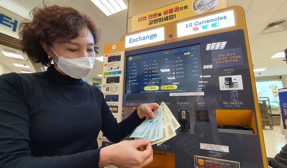  An Emart employee shows off Shinsegae Department Store gift certificates issued in exchange for foreign currency at Emart’s Seongsu branch in eastern Seoul on Thursday. Emart installed kiosks capable of exchanging paper money from 16 countries and coins from 11 countries into Shinsegae gift certificates at six of its branches including the Seongsu branch and Yongsan branch in central Seoul. [YONHAP] 