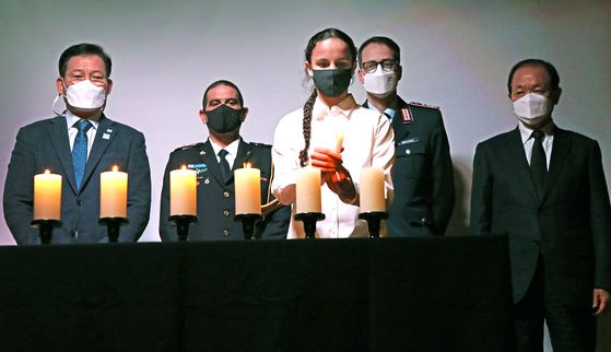 Shai Gambash, a representative of the Israeli youth in Korea, lights a candle to remember the victims of the Holocaust during the commemoration on Wednesday. Behind her, from left, are Song Young-gil, the chair of Foreign Affairs and Unification Committee of the National Assembly of Korea; Col. Yariv Ben Ezra, defense attaché of Israel in Korea; Col. Achim Neitzert, military attaché of Germany in Korea; and Hwang Woo-yeo, former deputy prime minister for social affairs and education minister. [PARK SANG-MOON]