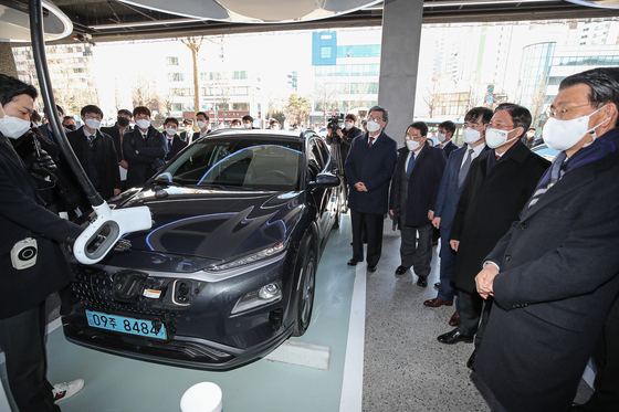 Eun Sung-soo, chairman of the Financial Services Commission, right, Sung Yun-mo, minister of trade, industry and energy, second from right, and other industry officials and executives watch a demonstration of Hyundai Motor’s Kona Electric’s rapid charging technology at Hyundai EV (electric vehicle) Station in Gangdong District, eastern Seoul, on Thursday. On the same day, Hyundai Motor Group in partnership with government bodies, financial institutions and private entities agreed to form a 200-billion-won ($178.8 million) worth fund within 2021 to invest in domestic auto parts companies to foster the country’s future mobility business. [YONHAP] 