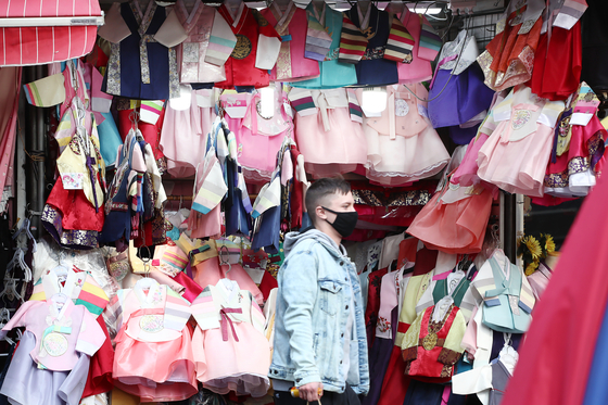 Korean traditional clothing, or hanbok, hanging at a store in Namdaemun, Seoul, on Sunday, less than a week before the Lunar New Year holidays. Usually during this period, one of the two most celebrated traditional holidays in Korea, sales surge with consumers opening up their wallet. But this year, as the government continues to implement strict social distancing in hopes of curbing the number of new Covid-19 cases, many stores fear heavy losses. [YONHAP]