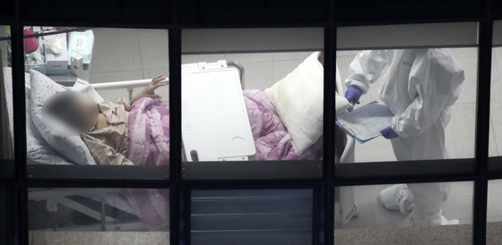 A patient at a long-term care hospital for the elderly in Ulsan being cared after by a caregiver in December 2020. [NEWS1]