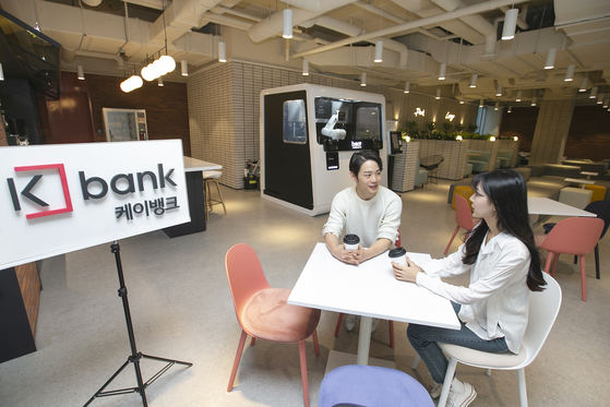 Workers talk in the new K bank office in Euljiro, central Seoul. The new office has been designed with top notch digital equipment to improve working environment, the internet-only bank said Tuesday. In the lounge, a coffee-making robot has been installed. [KBANK] 