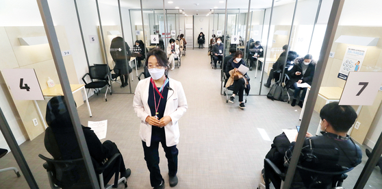 Medical workers and participants of a mock drill are on standby, at the National Medical Center in central Seoul on Tuesday, to run through the administering of Covid-19 vaccines as the government announced inoculations could begin on Feb. 26. [JOINT PRESS CORPS]