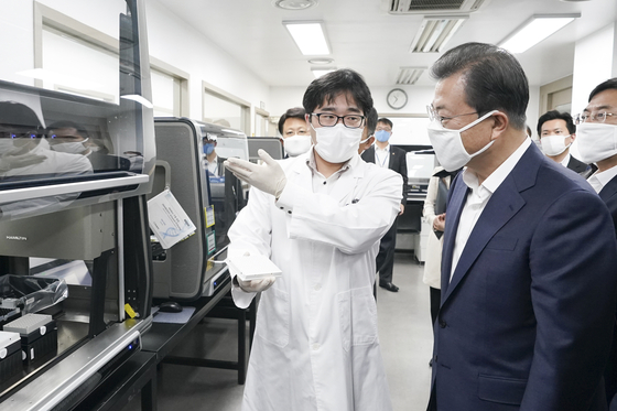 President Moon Jae-in, right, visits Seegene's research center in Songpa on March 25, 2020. [YONHAP]