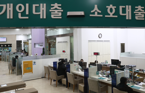 Consumers inquire about loans at a bank in central Seoul. [YONHAP]