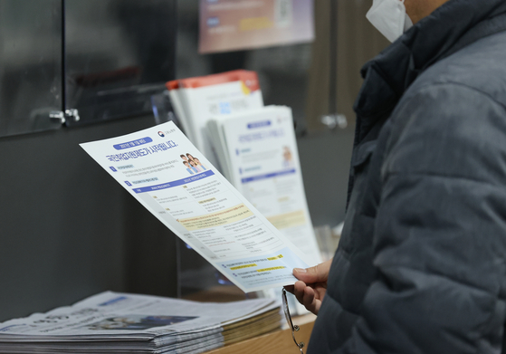 A job seeker looking at a booklet introducig government job programs at a center in Yeongdeungpo District on Feb. 3. The Statistics Korea on Feb. 10 announced that Janaury reported the worst job losses since the IMF crisis. [YONHAP] 