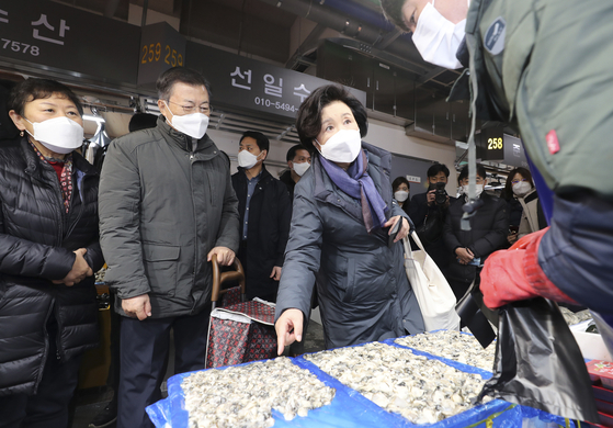 President Moon Jae-in and First Lady Kim Jung-sook buy fishery products for the Lunar New Year holiday at an outdoor fish market in Incheon on Wednesday. [JOINT PRESS CORPS]