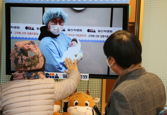 Grandparents welcome a grandchild born on the first day of 2021 via a monitor, because of social distancing regulations, in a hospital in Goyang, Gyeonggi. [YONHAP]