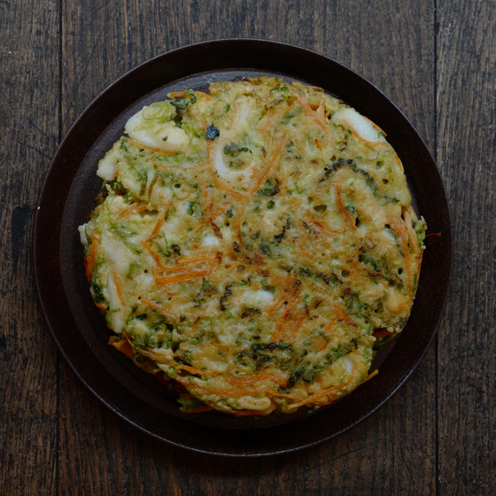 Haemul Pajeon, a Korean style savory pancake made mostly with scallions accompanied by all kinds of seafood, is widely loved for its crunchy texture that embraces the softer inside. Many Koreans usualy pair the dish with makgeolli, fermented rice drinks. The combnation of the two are most sought after on a rainy day. [AGENCE NEROLI]