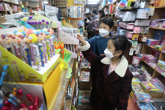 Students pick out school supplies a day ahead the new semester at a stationary store in Jongno District, central Seoul, on Monday. Under eased regulations, kindergarteners, first and second graders and high school seniors can go to school daily starting Tuesday. [NEWS1]