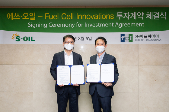 S-Oil President Ryu Yeol, left, and FCI representative director Lee Tae-won after the two companies forged a partnership at S-Oil headquarter in Mopo District, western Seoul, on Friday. [S-OIL] 