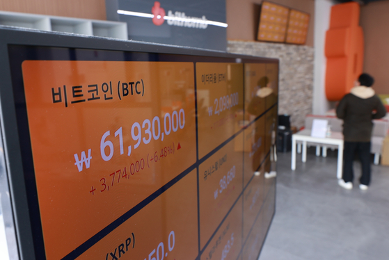 An electronic signboard at Bithum’s Gangnam center shows the value of bitcoin trading above 61 million won ($53,500), which is a new record, on Tuesday. While the Kospi has fallen below the 3,000 mark, investors have been flocking to the virtual currency. [YONHAP]