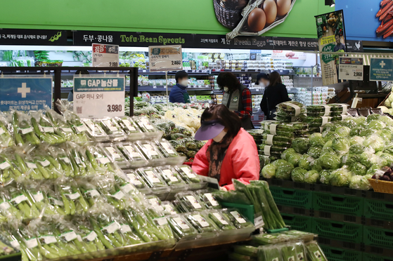 A shopper looks at vegetable at a discount store in Seoul on March 8. There has been growing worries over rising prices especially of food. [YONHAP] 