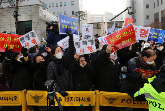 People hold up signs calling for a death sentence for the adoptive parents of a 16-month-old, who died after being brutally abused, at the Seoul Southern District Court on Wednesday, the fi rst day of the trial of the adoptive parents. [NEWS1]