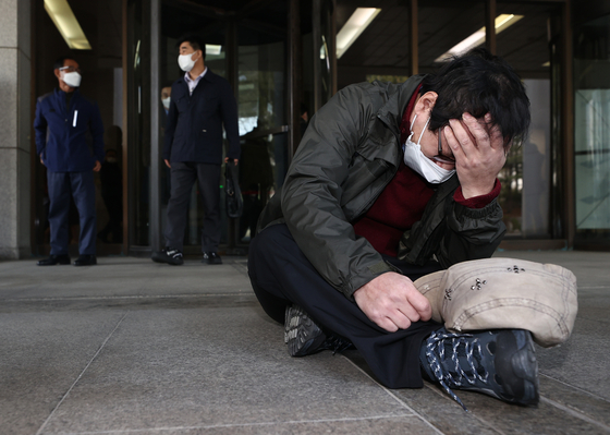 A former inmate of Brothers Home slumps on the floor outside the Supreme Court in Seoul on Thursday and cries upon the dismissal of an appeal filed against a not-guilty verdict for Park In-keun, the owner of Brothers Home, the state-run homeless facility. [YONHAP]