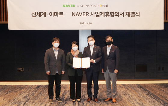 Representatives of Naver and Shinsegae celebrate a stock swap on Tuesday in southern Seoul. [YONHAP]