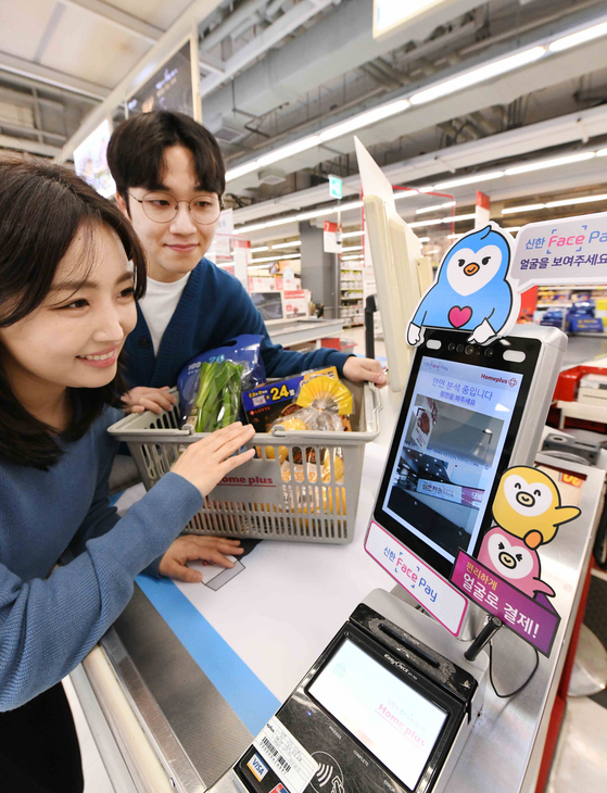 Models demonstrate digital payment systems using facial recognition technology at a Homeplus branch in Seoul. The giant discount retail chain announced Thursday that it is first among discount supermarkets to adopt “Shinhan Face Pay,” offered by Shinhan Card. [HOMEPLUS]