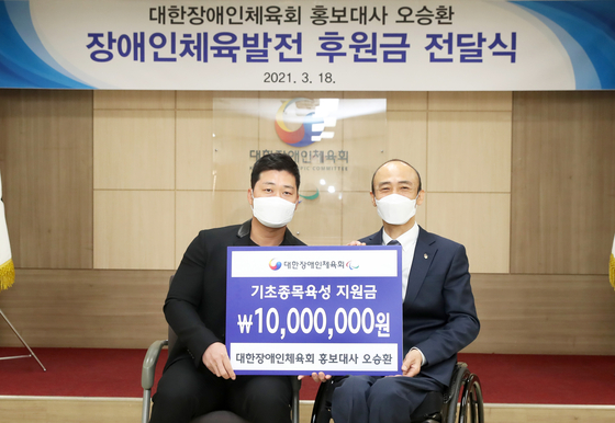 Samsung Lions closer Oh Seung-hwan poses with Korea Sports Association for the Disabled Chairman Chung Jin-wan at the organizations office in Songpa District, southern Seoul.