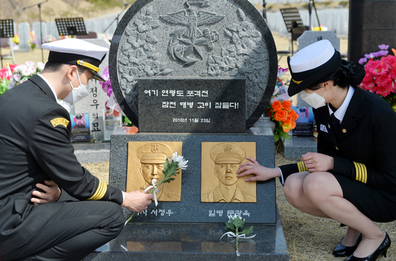 At Daejeon National Cemetery on Thursday, students from Mokpo National Maritime University pay their respects to two marines killed in artillery shelling by North Korea on Yeonpyeong Island on Nov. 23, 2010. Two marines and two civilians were killed and 30 marines were injured in the shelling. [KIM SEONG-TAE]