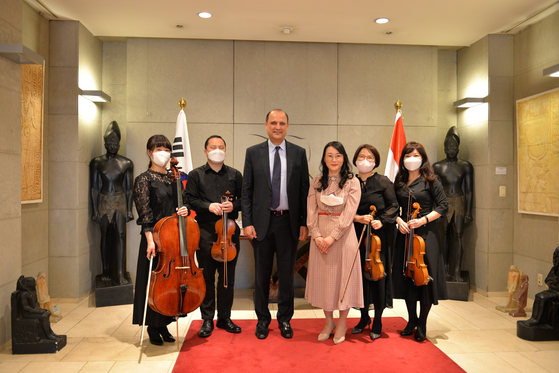 Kang Ju-hyun, author of ″The hidden tales in a papyrus bundle,″ third from right, and Egyptian Ambassador to Korea Hazem Fahmy, third from left, celebrate the publication of Kang's five-book series at the embassy in Seoul on Friday. The series is an illustrated edition about ancient Egyptian tales passed down from unknown Egyptian authors, dating from 2,050 B.C. to 600 B.C., with the stories translated directly to Korean from the original script in hieroglyphs and edited by Kang. Kang has also done all the illustrations in the series that reflect original Egyptian art and symbolism, according to the embassy. [EMBASSY OF EGYPT IN KOREA]