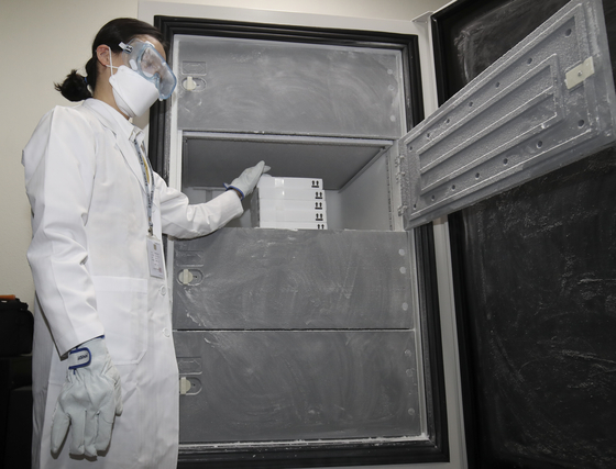 A medical staff member of a vaccination center in Ulsan stores Pfizer vaccines in a refrigerator on Wednesday. [NEWS1]