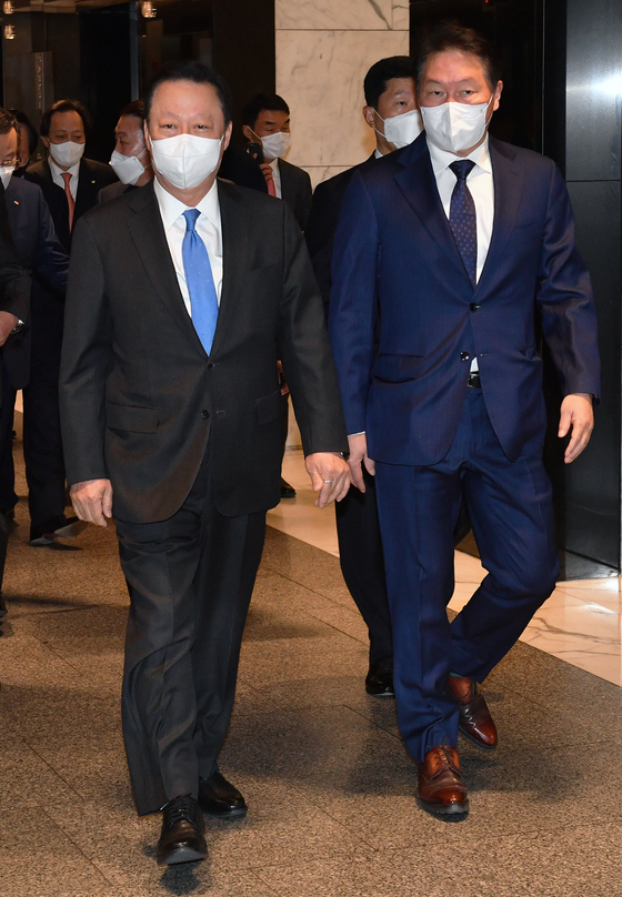 Korea Chamber of Commerce and Industry (KCCI) Chairman Chey Tae-won, right, accompanies Doosan Infracore Chairman Park Yong-maan at the KCCI headquarters in Jung District, central Seoul. Chey, the chairman of SK Group, took over from Park as KCCI chairman from Wednesday. [YONHAP]
