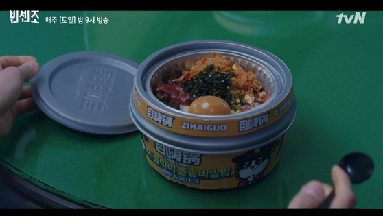  In the tvN series “Vincenzo” (2021), protagonists eat a bowl of ready-to-eat ‘bibimbap’ — a Korean rice dish mixed with vegetables and meat — from the Chinese brand Zihaiguo. Some raised concerns that the Mandarin packaging made bibimbap seem like a Chinese dish. [SCREEN CAPTURE] 