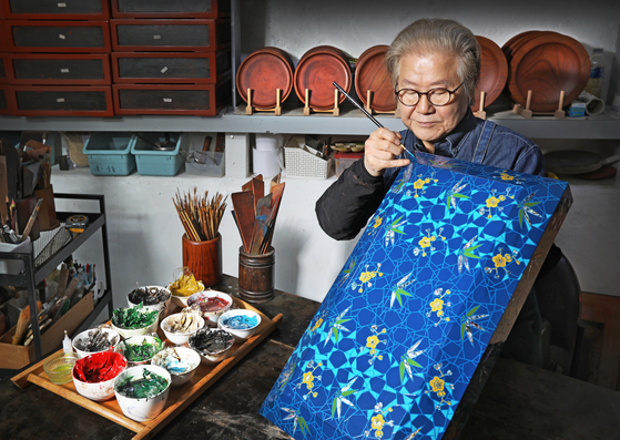  Artisan Choi Jong-kwan is adding the finishing touches to a plum and bamboo-patterned lacquer box using a fine-tip brush at his studio Chaehwa Lacquer Craft Institute in Donggyo-dong, Mapo District, western Seoul. [PARK SANG-MOON] 