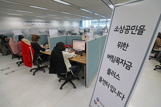 Call center employees in Daejeon handle inquires on the fourth emergency relief grants for small businesses on Tuesday. The emergency relief grants for small neighborhood shops, using funds created through this year’s first supplementary budget approved last week, started to accept applicants on Tuesday. [YONHAP]