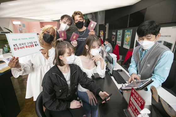Foreign customers listen to a KT employee talk about the mobile carrier's new mobile fee discount service aiming to benefit foreigners in Korea. [KT]
