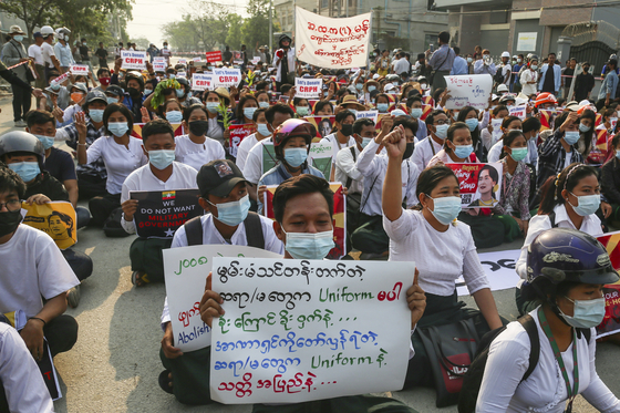 Demonstrators sit with placards during a protest against the military coup in Mandalay, Myanmar on Thursday. The Committee Representing the Pyidaungsu Hluttaw, a Myanmar government in exile representing Aung San Suu Kyi's National League for Democracy (NLD), announced that it plans to form a new coalition government with other democratic forces in the country. [EPA/YONHAP]