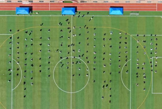 Students wait in line to get tested for Covid-19 at a high school in Dong District in Daejeon on Tuesday. Recently, teachers and students were confirmed positive with Covid-19 after a cluster of infections appeared at a cram school in the city. [YONHAP]