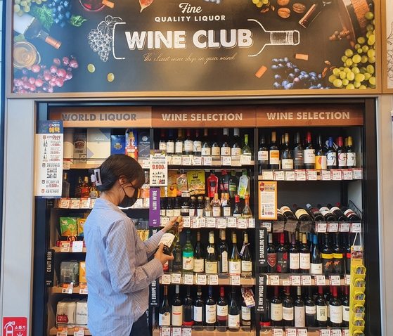 A customer looks at the wine section of an Emart24 convenience store. [EMART24]