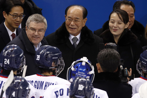 International Olympic Committee President Thomas Bach, left, then North Korean nominal head of state Kim Yong-nam, center, and Kim Yo-jong, right, the North Korean leader’s sister, greet players after a women's hockey game between Switzerland and an inter-Korean team at the PyeongChang Winter Olympics in Gangneung in February 2018. North Korea decided recently not to participate in the upcoming Tokyo Olympics because of coronavirus concerns. [AP/YONHAP] 
