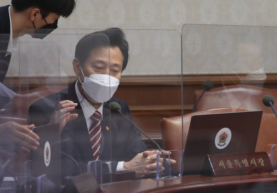 Seoul Mayor Oh Se-hoon, right, prepares to attend the cabinet meeting at the Central Government Complex in Seoul on Tuesday. [NEWS1]