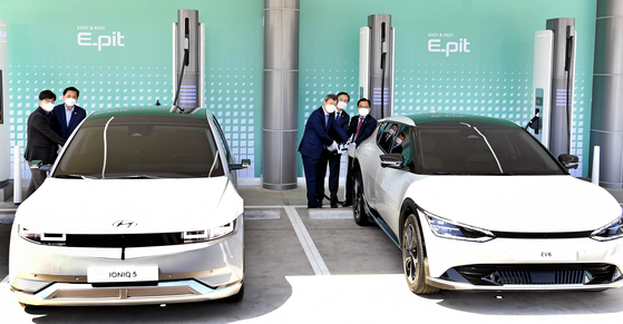Government officials and Hyundai Motor executives charge the Hyundai Motor Ioniq 5, left, and Kia EV6, at a Hyundai Motor charging station branded E-Pit that opened in Hwaseong, Gyeonggi on Wednesday. [HYUNDAI MOTOR]