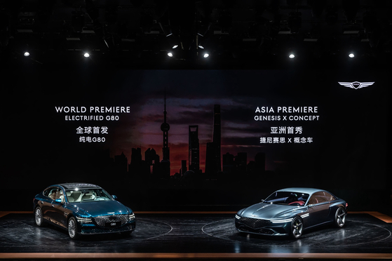 An electric version of the Genesis G80, left, and Genesis X concept model are on display at the Shanghai International Automobile Industry Exhibition on Monday. [HYUNDAI MOTOR]