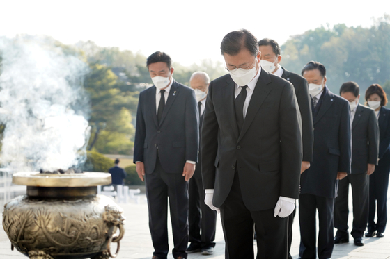 President Moon Jae-in, foreground, pays silent tribute at the monument at the April 19th National Cemetery in northern Seoul on Monday to commemorate the April 19 uprising. [YONHAP]