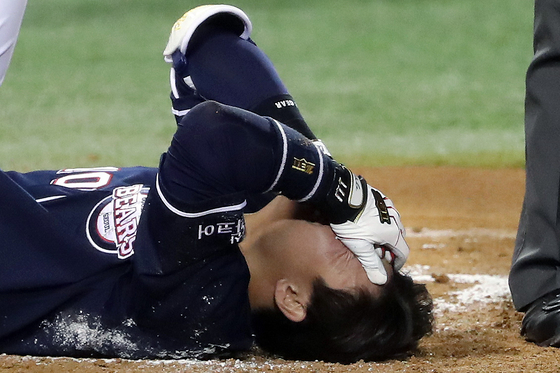 Park Sei-hyok lies on the floor in agony after getting hit in the head by a pitch during the eighth inning of a game between the Doosan Bears and LG Twins at Jamsil Baseball Stadium in southern Seoul on Friday. [NEWS1]
