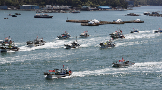 Some 160 fishing boats off the coast of Yeosu, South Jeolla, sail Monday in protest of Japan’s decision to dump contaminated water into the Pacific Ocean. [YONHAP]