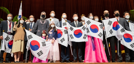 At the Central Government Complex in Gwacheon, Gyeonggi, on Wednesday, Justice Minister Park Beom-kye, center, poses for a photo with a group of expats who were naturalized through special procedure, after awarding them their certificate of Korean citizenship. [NEWS1]