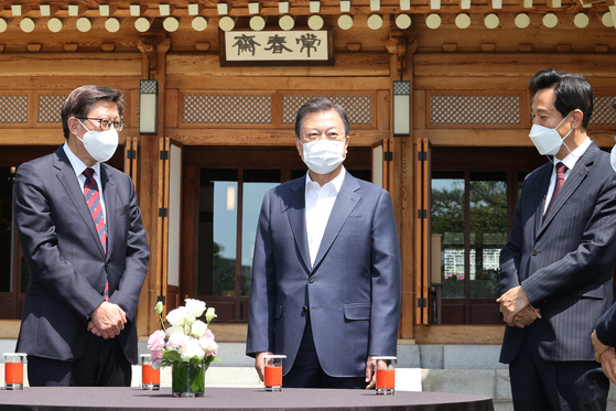 President Moon Jae-in, center, talks to Seoul Mayor Oh Se-hoon, right, and Busan Mayor Park Heong-joon at the Blue House on Wednesday. Moon invited the two mayors, elected on April 4, for a luncheon. [YONHAP]