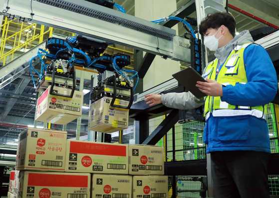 A CJ Logistics worker demonstrates an AI robot depalletizer at a fulfilment center in Dongtan, Gyeonggi. [CJ LOGISTICS]